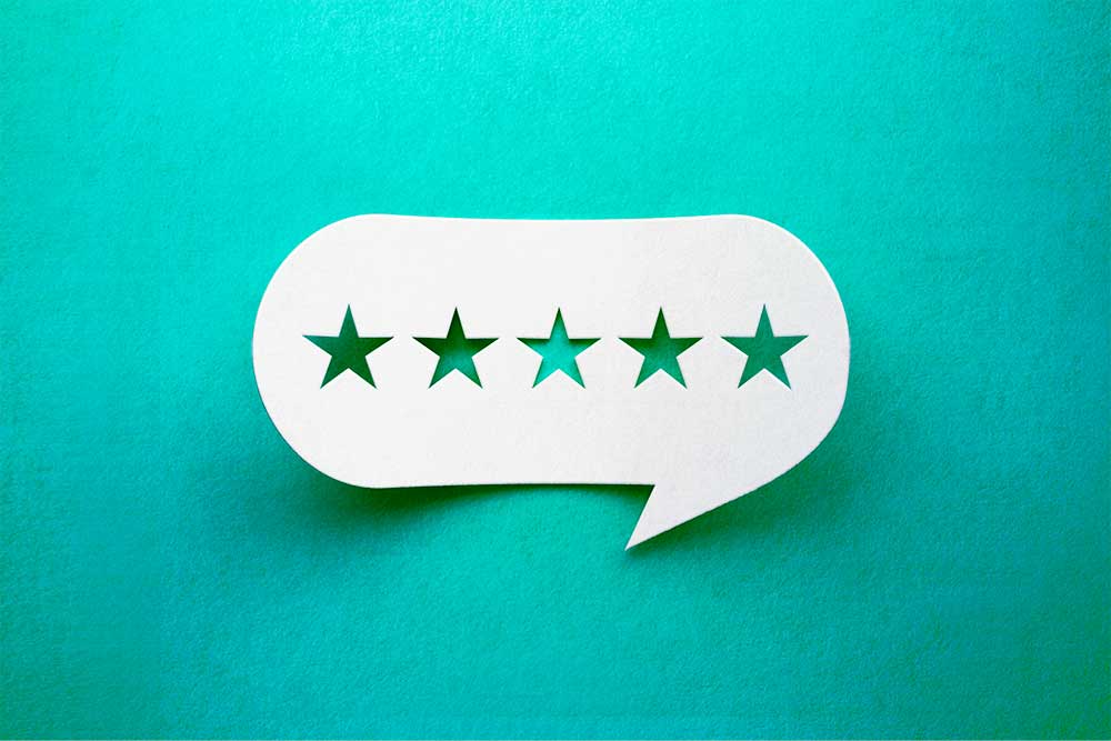 Online reviews featured image white cutout speech bubble with 5 stars on green background